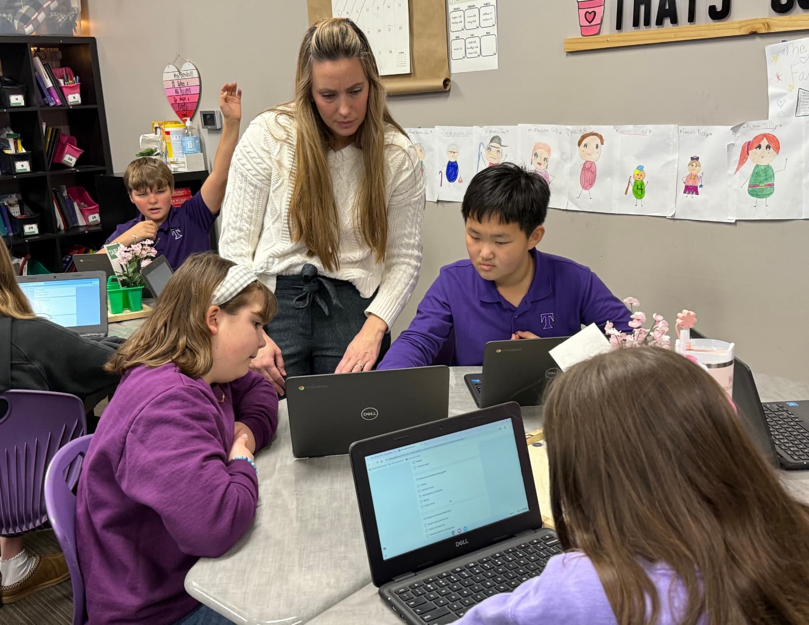 TCS students collaborating with a teacher and classroom technology