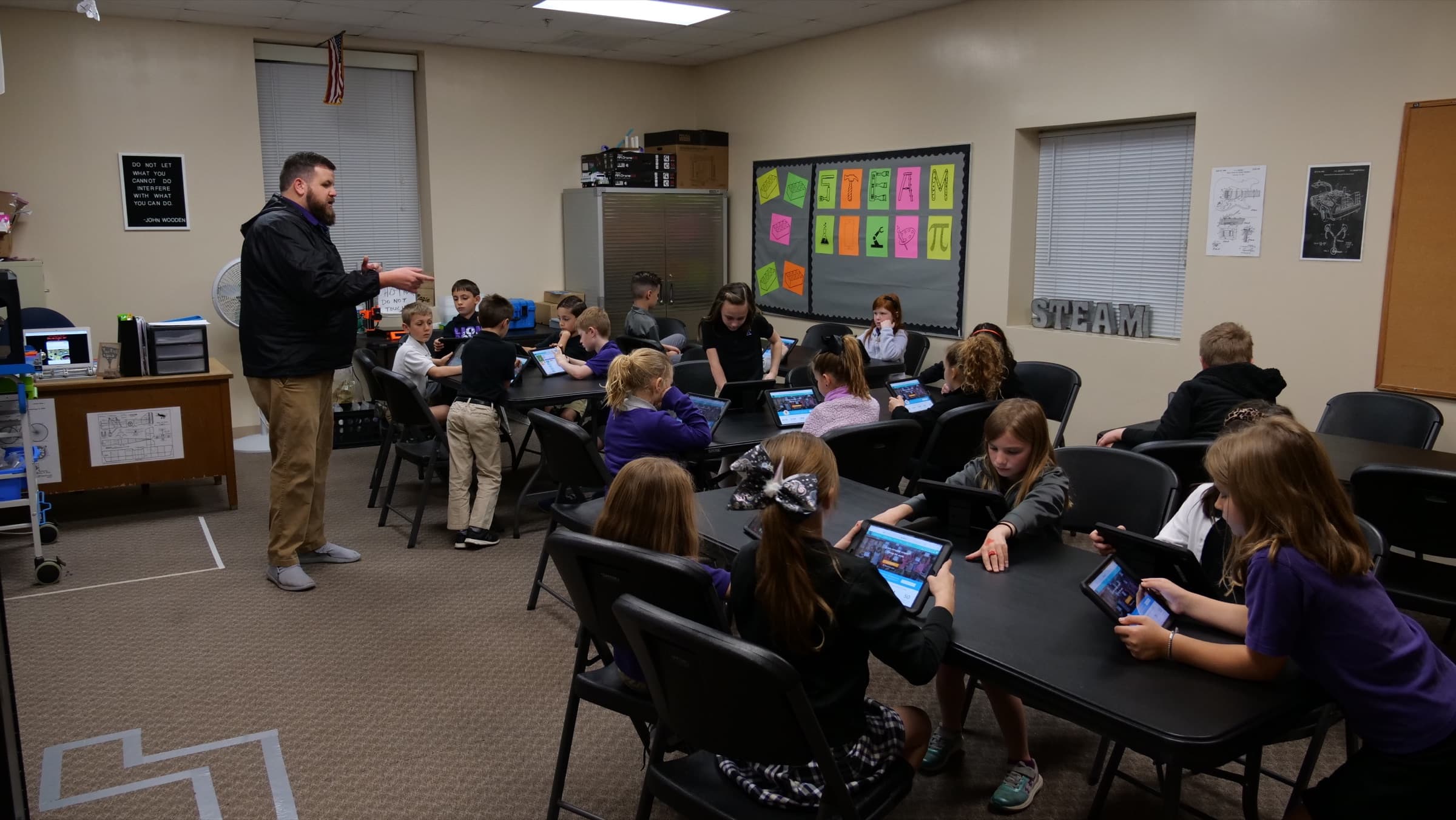 Upper-elementary TCS students working with tablets during a STEAM lesson